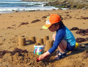 Niño jugando en la playa con protección solar
