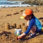 Niño jugando en la playa protegido del sol