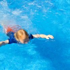 niño aprendiendo a nadar