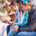 Adolescentes mirando a sus teléfonos móviles