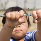 Niño detrás de una alambrada