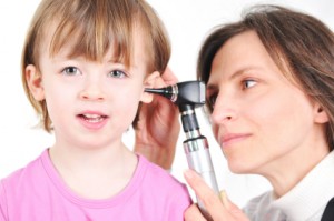 Pediatra explorando el oído de una niña