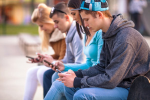Adolescentes mirando a sus teléfonos móviles