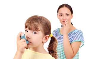 Adulto fumando al lado de niña con asma