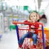 Niña subida a un carro de la compra