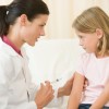 Enfermera poniendo vacuna a una niña